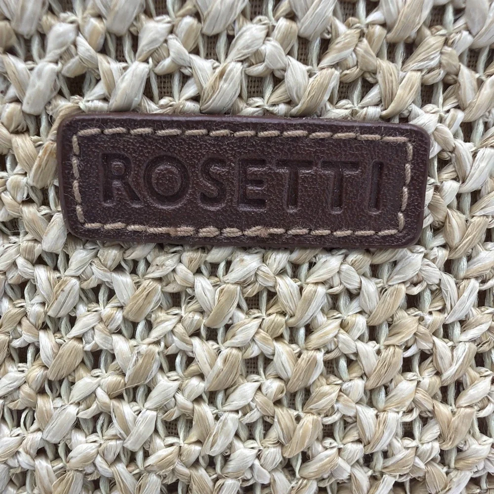 Rosetti straw tote handbag with brown faux leather trim‎ and top handles.